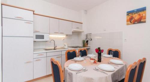 a kitchen with a table and chairs in a kitchen at Apartments Nikolina in Split