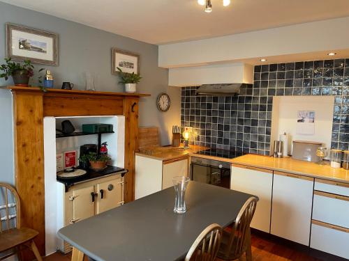 eine Küche mit einem Tisch und Stühlen in der Unterkunft 1 Keepers Cottage Skeabost Bridge Isle Of Skye in Skeabost