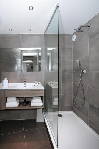a bathroom with a shower and a sink and a tub at Best Western Linko Aubagne in Aubagne