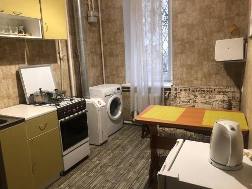 een keuken met een fornuis en een wasmachine. bij 1 ком квартира с газом вблизи ЖД вокзала in Odessa