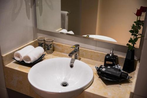 a bathroom with a white sink and a mirror at Hanoi Lakeside Premium Hotel & Travel in Hanoi