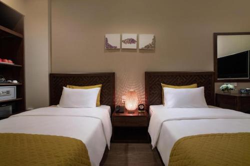 a hotel room with two beds and a tv at Hanoi Lakeside Premium Hotel & Travel in Hanoi