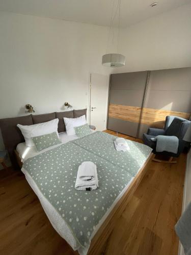 a bedroom with a large bed and a chair at Reusenhaus Süd in Breege