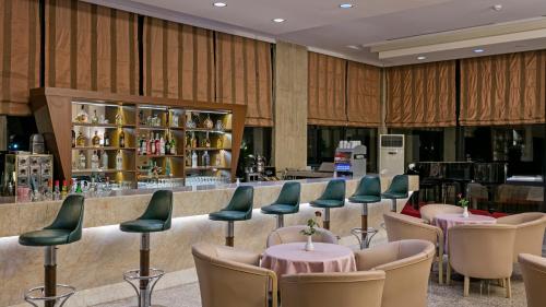 a lobby with a bar with chairs and tables at Özkaymak Falez Hotel in Antalya
