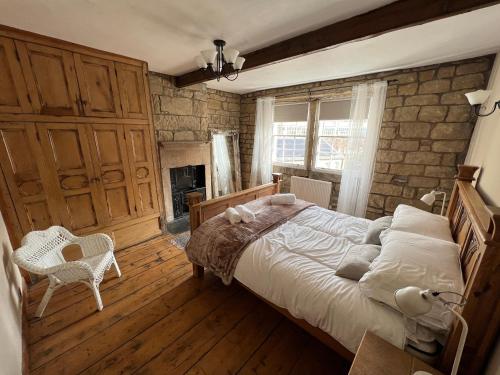 1 dormitorio con 1 cama grande y pared de ladrillo en Meg's Den en Hebden Bridge