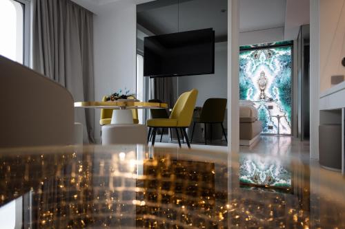 sala de estar con mesa y sillas amarillas en Ghibli Hotel, en Civitanova Marche