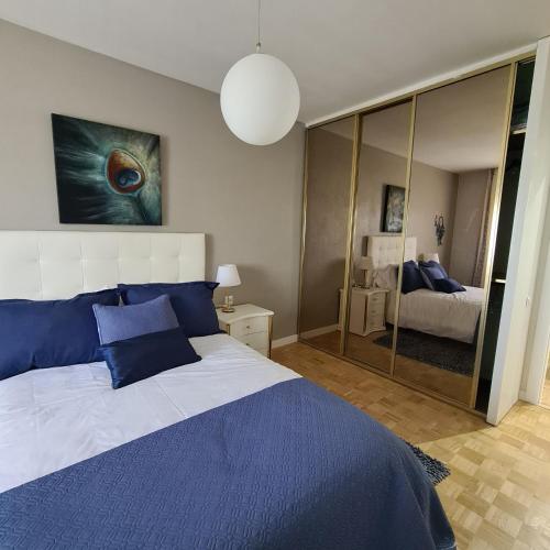 a bedroom with a blue and white bed and a mirror at CORAZON RIBEIRA SACRA in Monforte de Lemos