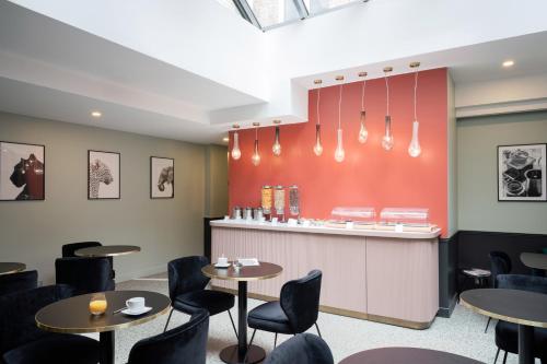 a restaurant with tables and chairs and a counter at Hôtel 31 - Paris Tour Eiffel in Paris