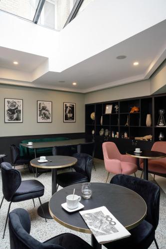 a dining room with tables and chairs and a room with shelves at Hôtel 31 - Paris Tour Eiffel in Paris