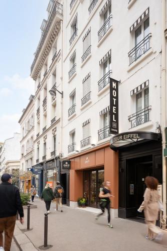 people walking down a street in front of a building at Hôtel 31 - Paris Tour Eiffel in Paris