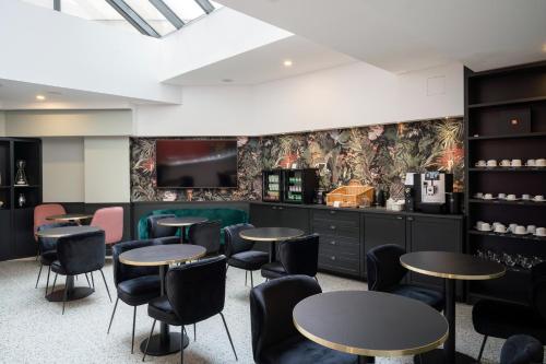 a restaurant with tables and chairs and a tv at Hôtel 31 - Paris Tour Eiffel in Paris