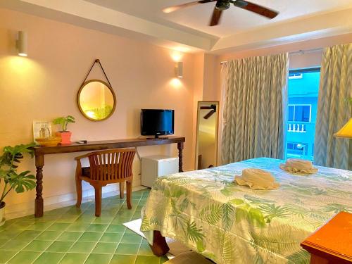 a bedroom with a large bed and a television at BE Rendez Vous Hotel in Patong Beach