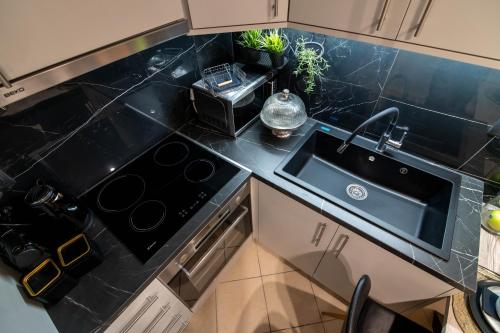 a kitchen with a black counter top with a sink at Elite and Style in Preveza