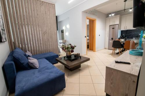 a living room with a blue couch and a table at Elite and Style in Preveza