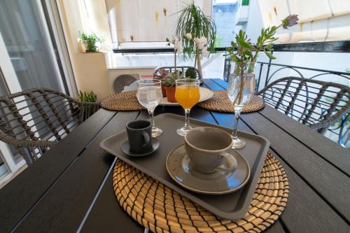 a table with a tray with a cup and two glasses at Elite and Style in Preveza