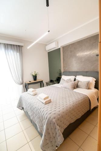 a bedroom with a large bed with towels on it at Elite and Style in Preveza