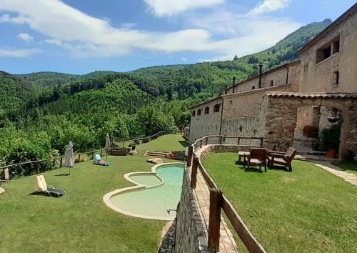 a view of an old building and a swimming pool at Mas Vilar, relax, nature and slow Exclusive Only 6 rooms in Arbúcies