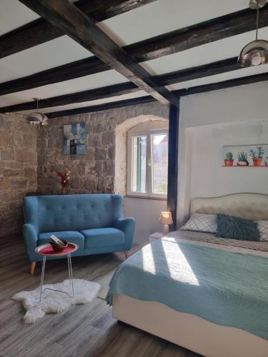 een slaapkamer met een bed en een blauwe bank bij Heritage Apartments Trumbić in Split