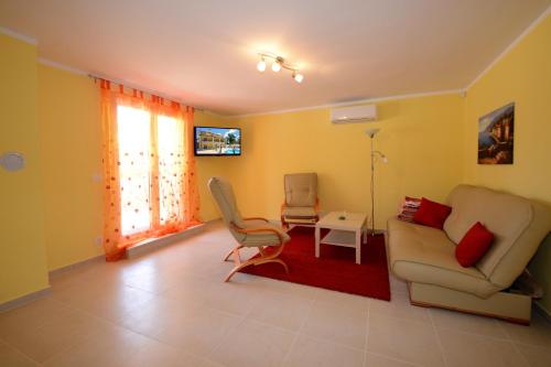 a living room with a couch and a table at Apartments Villa Mimi in Višnjan