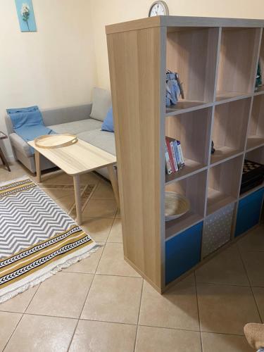 a living room with a table and a book shelf at Tiny Bijou Sea View studio - Santa Marina - Sozopol in Sozopol