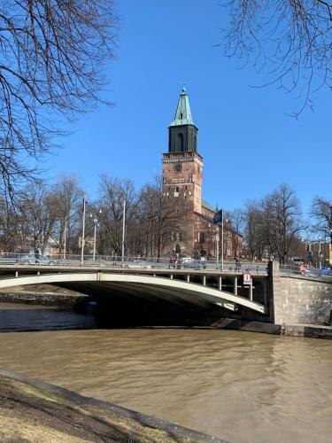 a bridge over a river with a clock tower at Holiday Home Turku City in Turku
