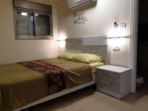 ein kleines Schlafzimmer mit einem Bett und einem Fenster in der Unterkunft Kiryat Tivon, Close by - Oranim College + parking in Oranim