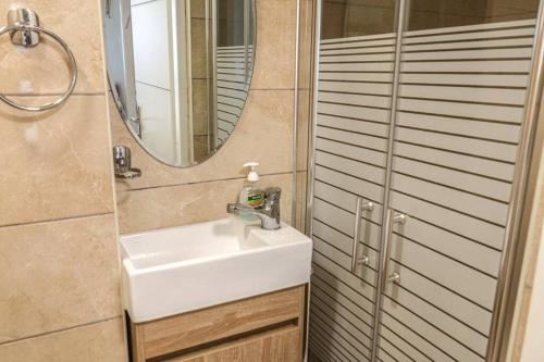 a bathroom with a sink and a mirror at Kiryat Tivon, Close by - Oranim College + parking in Oranim