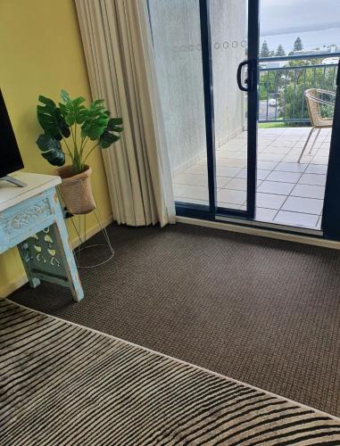 a room with a desk and a door to a balcony at Casablanca Penthouse Loft - Landmark 518 in Nelson Bay