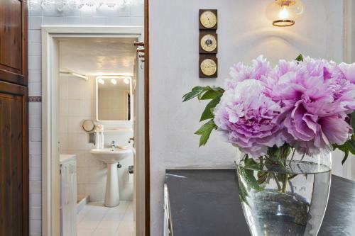 a vase of purple flowers sitting on a table in a bathroom at Villa Rica by Wonderful Italy in Santa Margherita Ligure