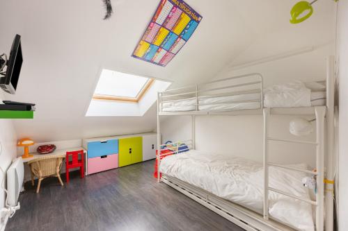 une chambre avec un lit superposé et un bureau dans l'établissement Le Cockpit, à Courseulles-sur-Mer