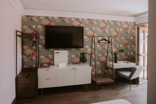 a living room with a tv on a wall with flowers at Matiana Estudiante in Zacatecas