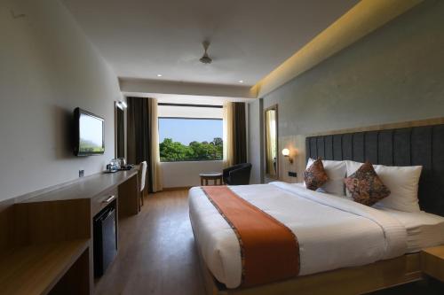 a hotel room with a bed and a large window at HOTEL KLG ALTORIA in Chandīgarh