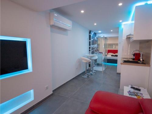 un salon avec un canapé rouge et une télévision dans l'établissement Village Naturiste Coursive Port Nature 2 Vue Mer, au Cap d'Agde