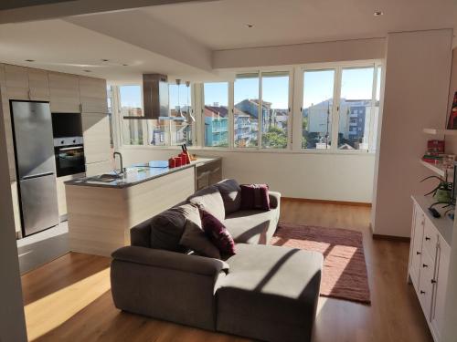a living room with a couch and a kitchen at M&H Loft - Apartamento T2 em Setúbal in Setúbal
