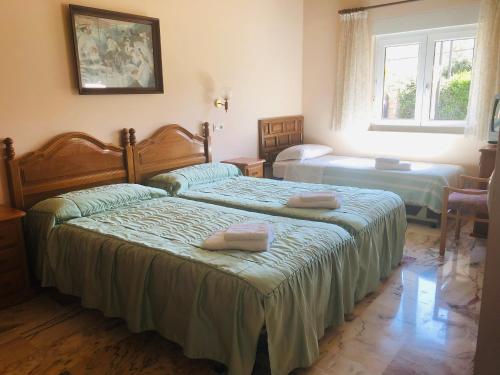 - une chambre avec 2 lits et des serviettes dans l'établissement Posada El Urogallo en Renedo de Cabuérniga, à Renedo