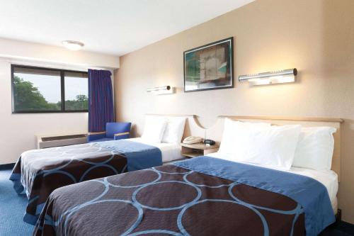 a hotel room with two beds and a window at Days Inn by Wyndham Monmouth Junction-S Brunswick-Princeton in Monmouth Junction