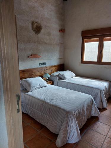 Habitación con 2 camas y ventana en El Refugio de las Arribes, en Villarino de los Aires