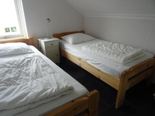2 camas individuais num quarto com uma janela em Kustverhuur, Vakantiepark Fort Soleil 33 em Breskens