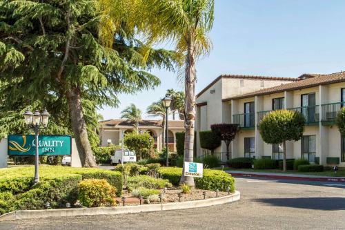 a sign in front of a building with palm trees at Quality Inn & Suites South San Jose - Morgan Hill in Morgan Hill