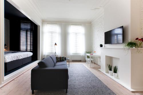 a living room with a couch and a bed at Maison Nationale City Flats & Suites in Antwerp