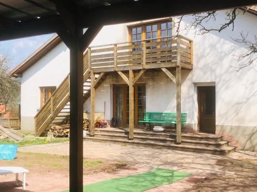 la ferme de manu في Saulxures: يتم بناء منزل مع مقاعد خضراء في الأمام