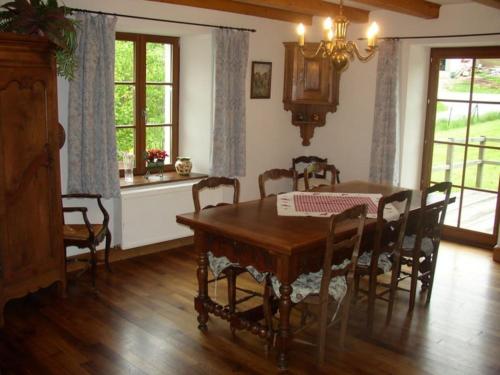 a dining room with a wooden table and chairs at La Parrière in Le Saulcy
