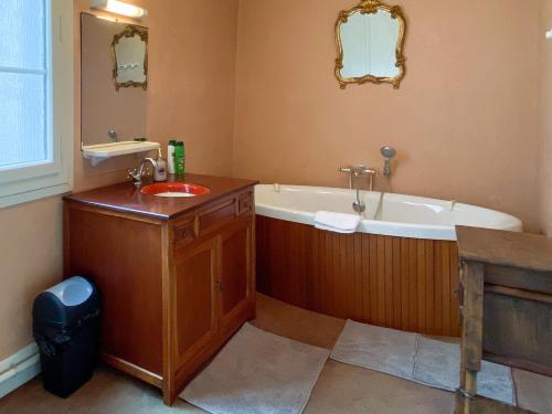 a bathroom with a bath tub and a sink at Nogapatio - Maison d'Hôtes - BnB in Nogaro