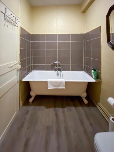 a bathroom with a bath tub and a sink at Nogapatio - Maison d'Hôtes - BnB in Nogaro