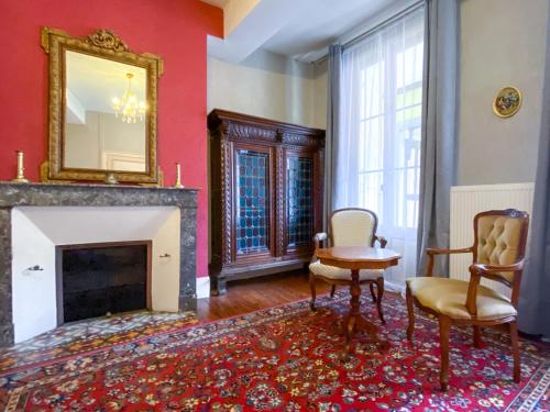 a living room with a fireplace and a mirror at Nogapatio - Maison d'Hôtes - BnB in Nogaro