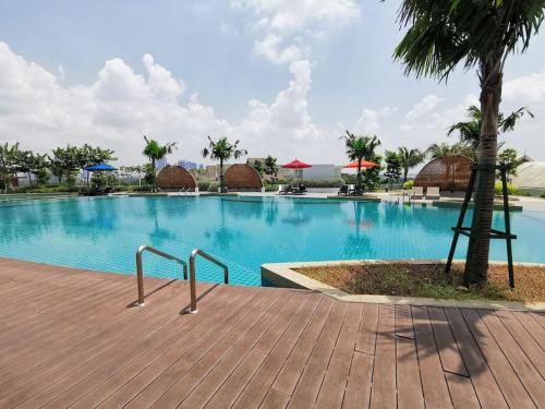 a large swimming pool with blue water and palm trees at MUJI STYLE STUDIO Almas 100mbps Pool View Netflix By STAY in Nusajaya