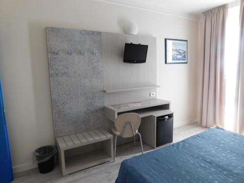 a bedroom with a desk and a bed and a chair at Hotel Oceano in Marina di Pietrasanta