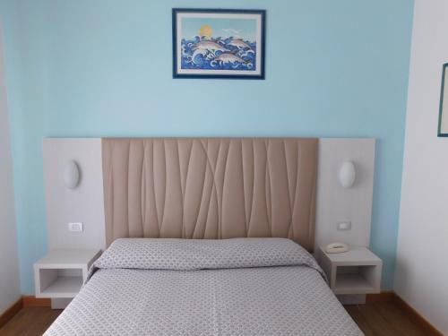 a bedroom with a bed with a blue light above it at Hotel Oceano in Marina di Pietrasanta