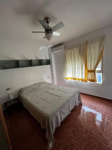 een slaapkamer met een bed en een plafondventilator bij LA VERDE in Alicante