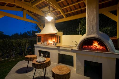 a outdoor oven with two tables and a stove at Dorothea Villa in Zakynthos Town